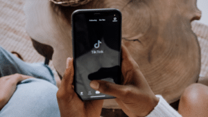 A person holding a phone with the Tinder app on it, analyzing TikTok data.