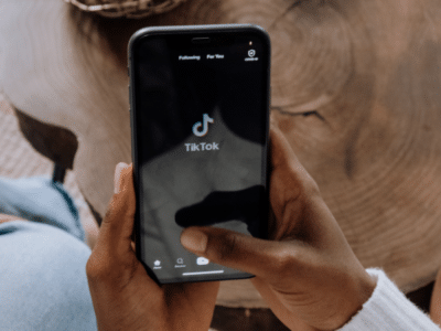 A person holding a phone with the Tinder app on it, analyzing TikTok data.