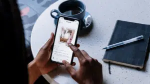 A woman holding a phone and a notebook at a table promoting an Instagram Merch Shop.