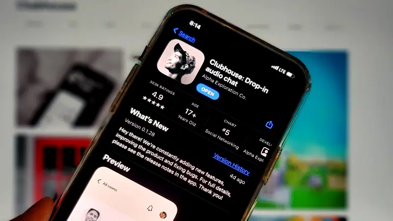 A person is holding a Clubhouse app on their phone.