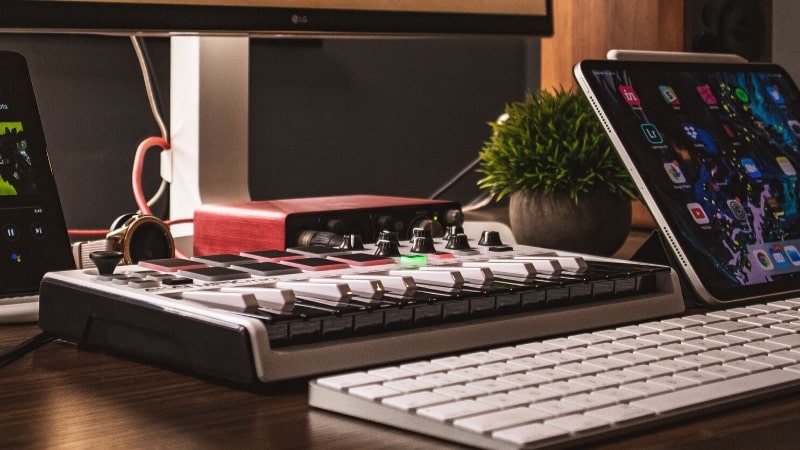A desk with an iPad and keyboard on it, featuring Soundcloud.