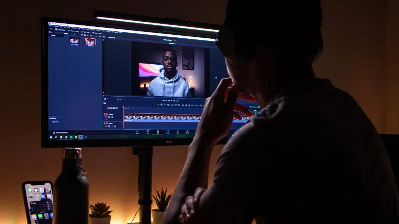 A man is watching a video on a computer screen, checking the content ID.