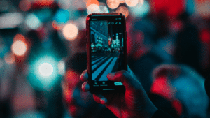 A person capturing a crowd at night using Instagram's algorithm.