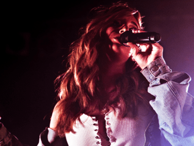 A woman performing live music on stage.