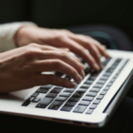 Hands typing on a SplitShare-enhanced laptop keyboard.