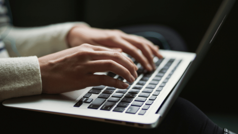 Hands typing on a SplitShare-enhanced laptop keyboard.