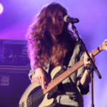 A woman playing a bass on stage.