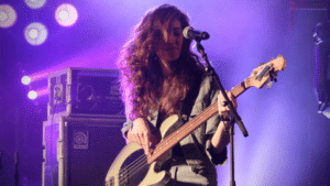 A woman playing a bass on stage.