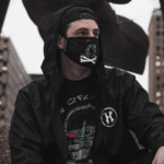 A man wearing a black hoodie and a face mask to prevent COVID.