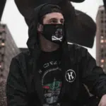 A man wearing a black hoodie and a face mask to prevent COVID.