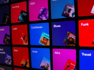 An image of a colorful screen displaying various types of music, reminiscent of Spotify.