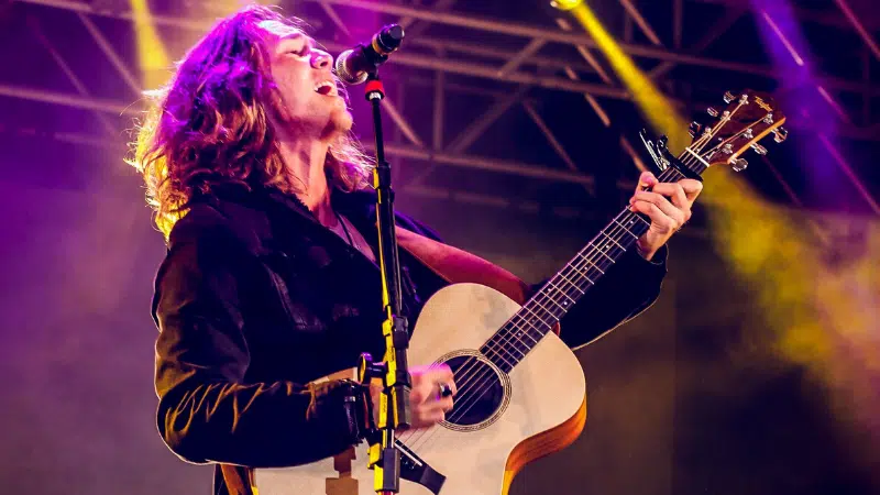 A man performing live music with an acoustic guitar.