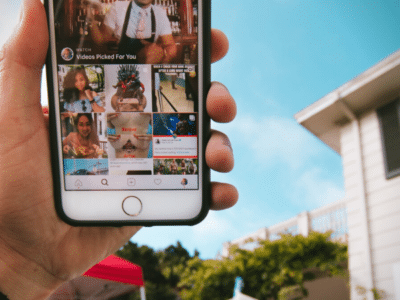 A person proudly displaying an iPhone with an Instagram-inspired photo of a house.