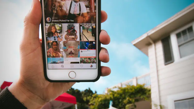 A person proudly displaying an iPhone with an Instagram-inspired photo of a house.