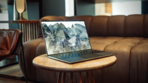 A laptop displaying NFT's sitting on a wooden table in a living room.