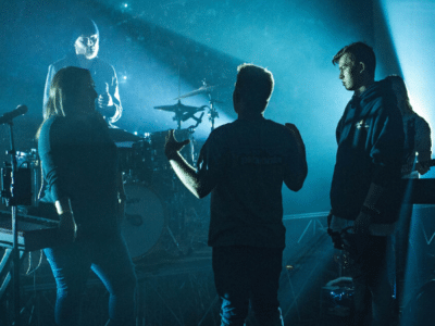 A group of people standing on stage in front of a bright light.