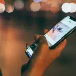 A woman using a cell phone at night for sales purposes.