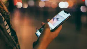 A woman using a cell phone at night for sales purposes.