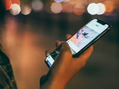 A woman using a cell phone at night for sales purposes.