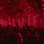 A crowd of people at a concert with red lights is an exhilarating experience for musicians performing on stage. It serves as a mesmerizing visual backdrop and further enhances the energy and atmosphere of the music.