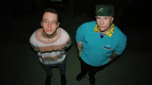 Two men standing in a dark room.