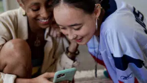 Two women looking at a TikTok video on a cell phone.