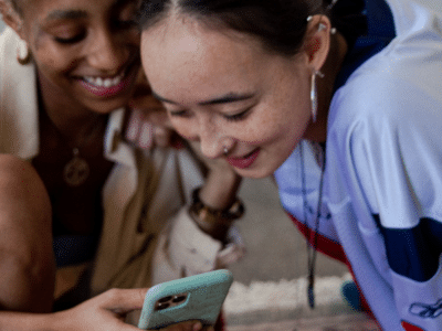 Two women looking at a TikTok video on a cell phone.