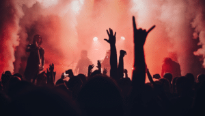 A tour concert with people raising their hands in the air.