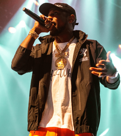 A man promoting with a microphone on stage.