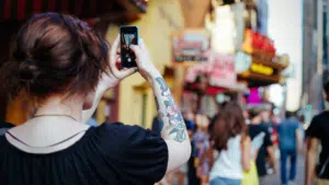 A woman is taking a picture with her cell phone for Instagram.