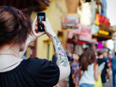 A woman is taking a picture with her cell phone for Instagram.