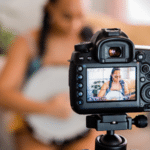 A woman is filming a video with a camera for YouTube views.