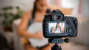 A woman is filming a video with a camera for YouTube views.