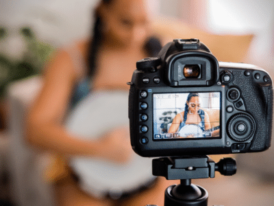 A woman is filming a video with a camera for YouTube views.