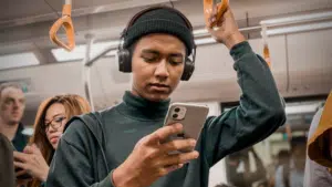 A man on a subway scrolling through Instagram on his phone.