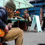 A man serenades on a bench with his guitar, demonstrating how to develop your story.