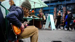 A man serenades on a bench with his guitar, demonstrating how to develop your story.