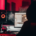 A person in a hoodie sitting in front of a computer exploring NFTs.