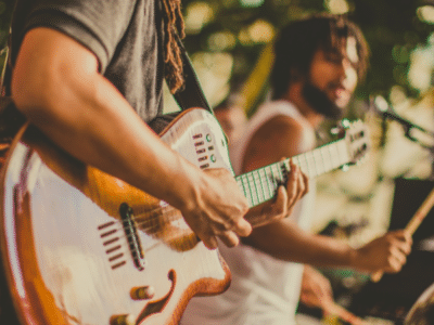 A group of people playing guitar at a music festival, promoting pre-saves.