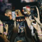 A group of people using Instagram at a concert.