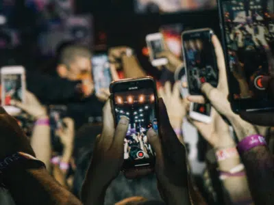 A group of people using Instagram at a concert.