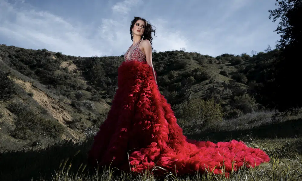 A woman in a dress standing in a field.