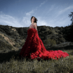 A woman in a dress standing in a field.