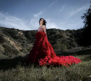 A woman in a dress standing in a field.