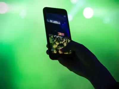 A person is capturing a concert moment with their cell phone for an Instagram Reels video.