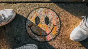 A pair of shoes promoting mental health with a smiley face painted on them.