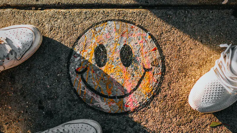 A pair of shoes promoting mental health with a smiley face painted on them.