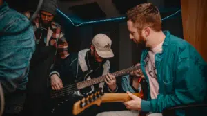 A group of people playing guitar in a recording studio in 2023.