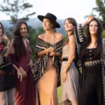 A group of women posing for a picture in a field.