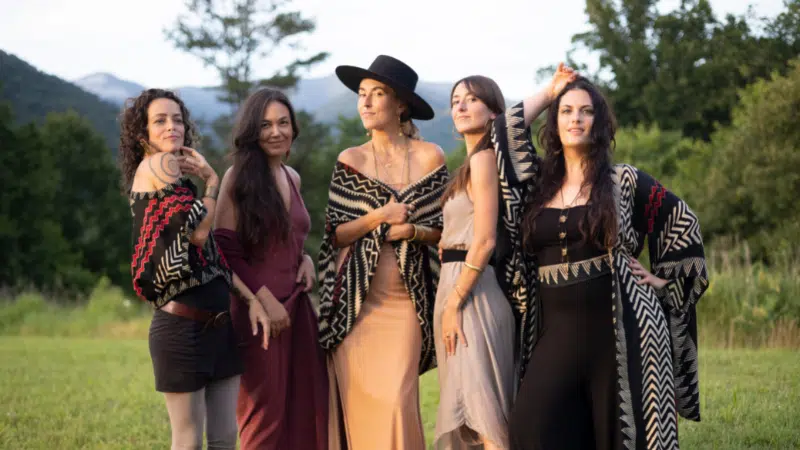 A group of women posing for a picture in a field.